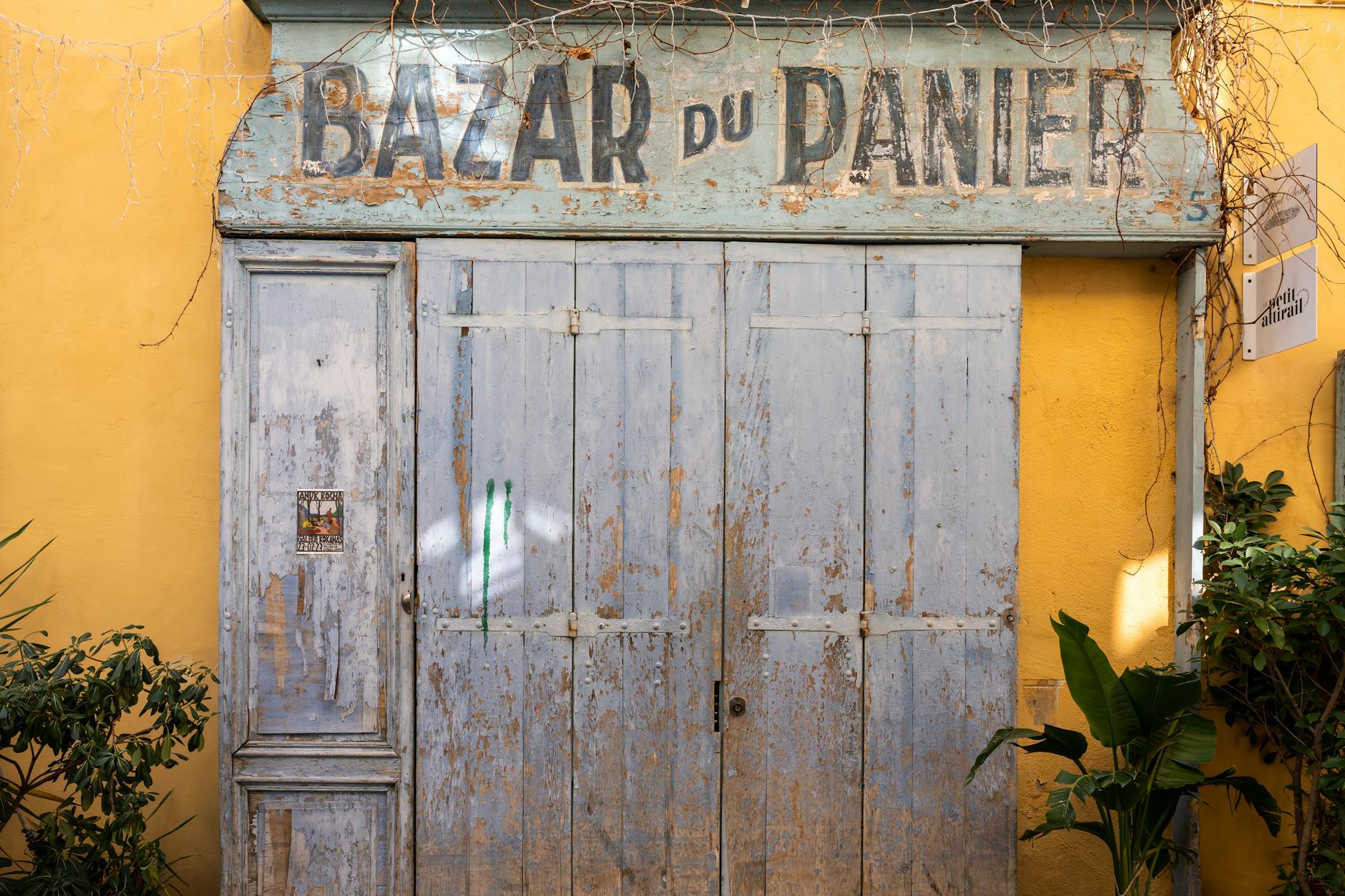 Drewniane drzwi Bazar du Panier na słonecznej francuskiej uliczce