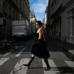 Słowa o modzie po francusku: 30 przydatnych wyrażeń Elegancka kobieta przechodzi przez paryską ulicę w stylu francuskim