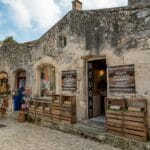 Prowansja inaczej: lawenda poza sezonem i jak rozmawiać z lokalnymi Kamienna fasada sklepu z lokalnymi produktami w Les Baux-de-Provence