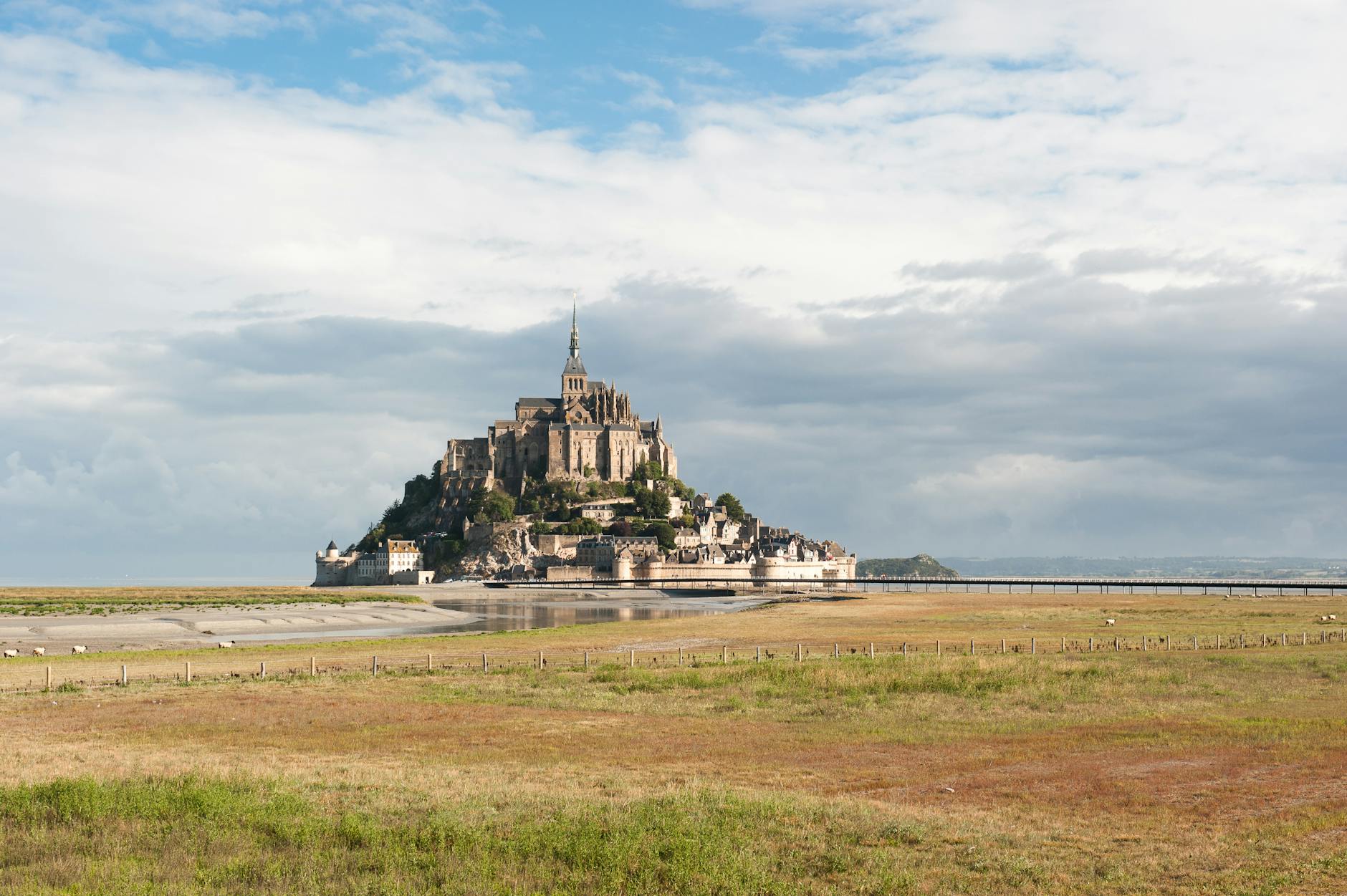 Widok Mont Saint Michel otoczonego wodą w słoneczny dzień