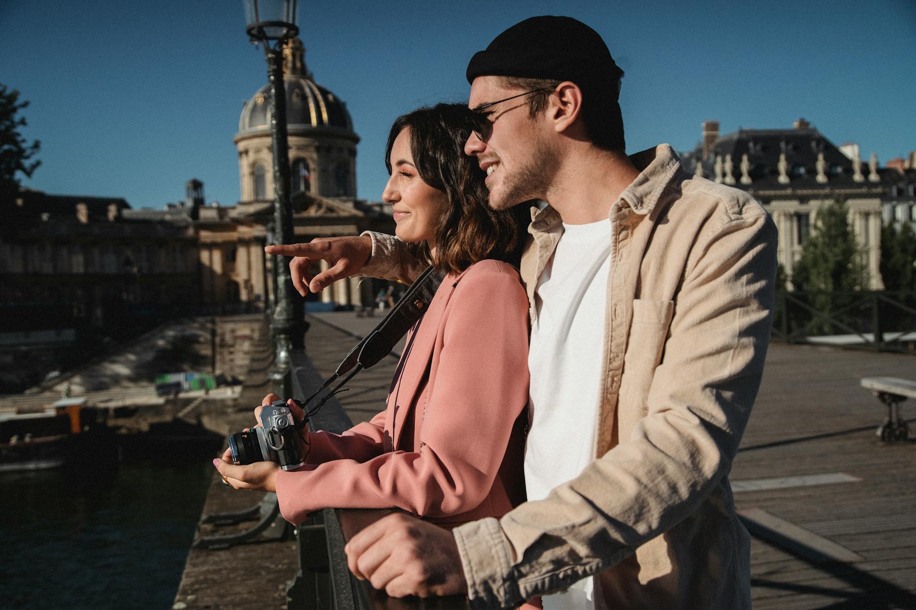 Para w eleganckich strojach spaceruje po Paryżu z aparatem fotograficznym