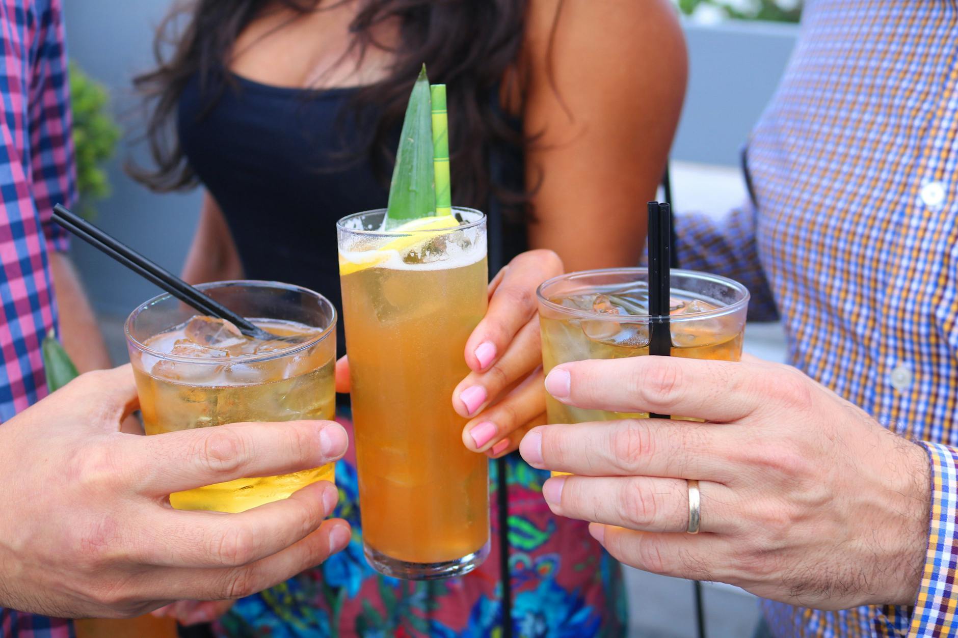 Przyjaciele wznoszą toast koktajlami podczas wieczornego apéro na zewnątrz