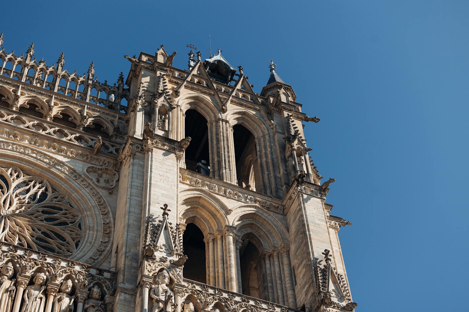 Detaliczna fasada gotyckiej katedry w Amiens na tle błękitnego nieba