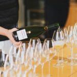 Szampania poza Reims: małe domy szampańskie i jak pytać o rodzaje brut Nalewanie kieliszka szampana podczas degustacji w Aÿ w Szampanii